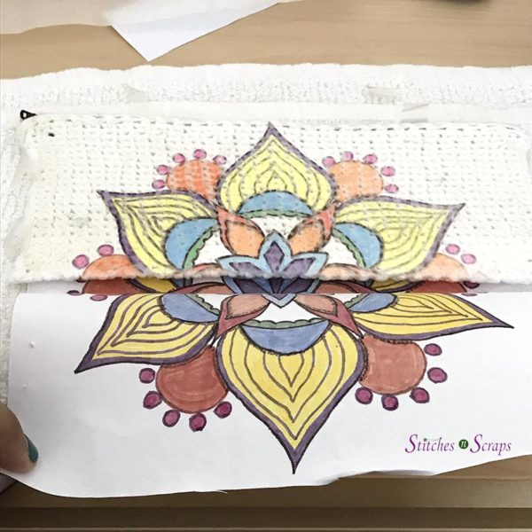 Paper with mandala design pulled back to reveal image transferred onto white pencil case. Personalized Pencil Case on Stitches n Scraps