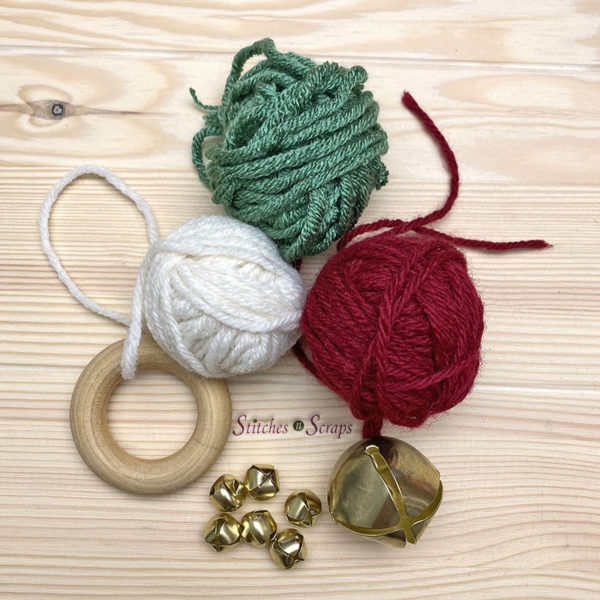 red, white and green yarn balls, a wood ring, 6 small bells, and 1 large bell