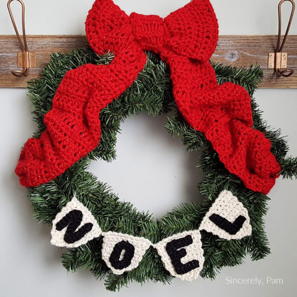 A wreath with a large bow and a bunting that says Noel. Noel Wreath Bunting from Sincerely Pam