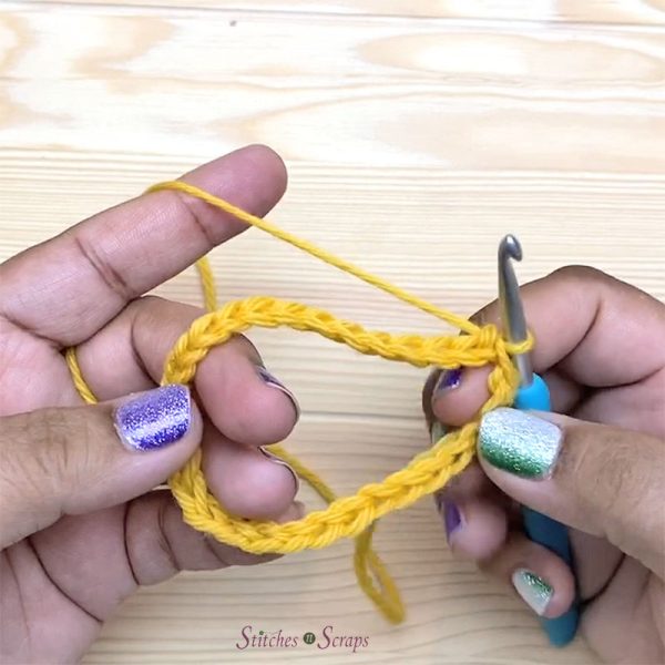 A crochet chain joined in the round by pulling the working loop through the first chain.