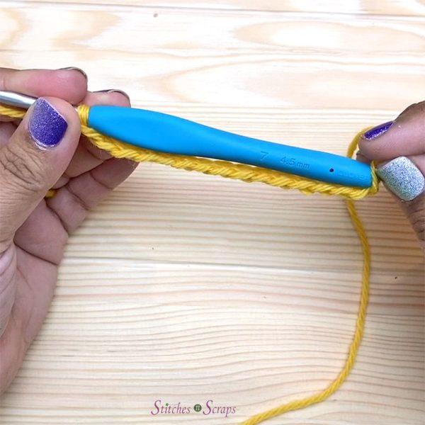 Sliding the first chain over the back end of a crochet hook.