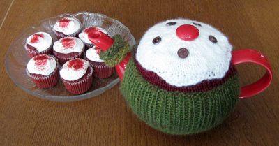 March tea cozy next to a plate of mini cupcakes