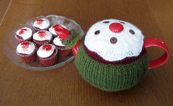 March tea cozy next to a plate of mini cupcakes