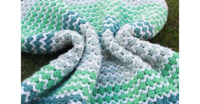 Blue, green, and white crocheted blanket on white background with text - Scrappy Stitchers Link Party 53 - most clicked last month Spring to Life Crochet Baby Blanket from Ned & Mimi.