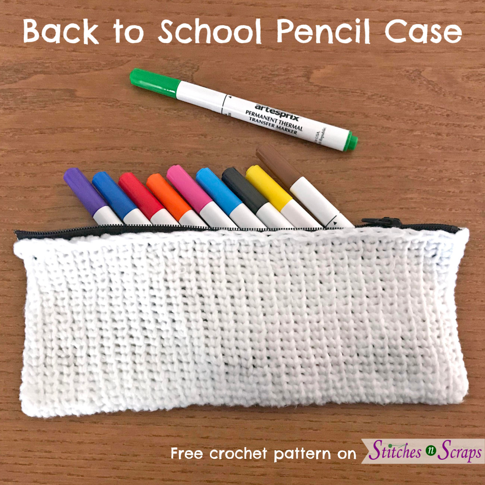 White, crocheted pencil case with a black zipper, on a wood table. Pencil case is full of markers in different colors. Back to School Pencil Case from Stitches n Scraps
