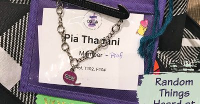 A name badge for the CGOA chain link conference, with several ribbons, pins, and chains attached