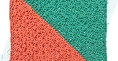 A diagonally crocheted washcloth with coral on one side and teal on the other. Symbiosis, a free crochet pattern on Stitches n Scraps