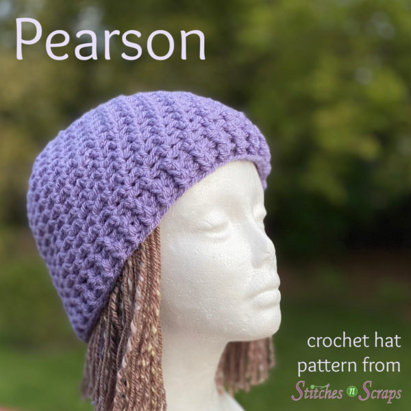 A foam mannequin head with brown hair, wearing a lavender crochet beanie. Text says "Pearson - crochet hat pattern on Stitches n Scraps"