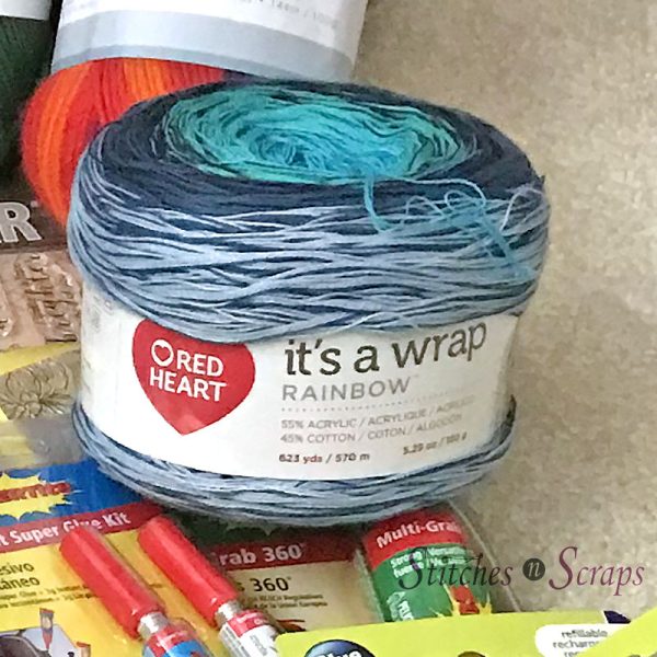 It's a Wrap Rainbow yarn, in a pile of other craft supplies