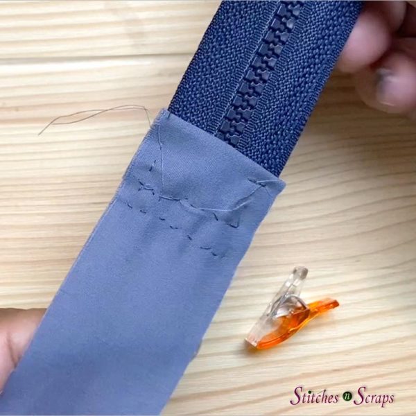 End of zipper sewn to the end of a strip of fabric that is approximately the same width. 