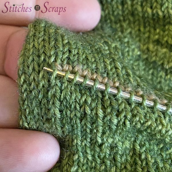 Pick up an extra stitch at the edge of the heel opening